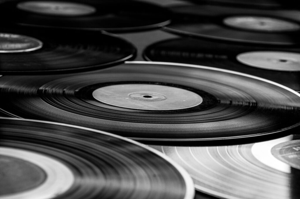 Schwarz-weiß-Fotografie von mehreren nebeneinander liegenden Vinyl-Schallplatten in Nahaufnahme.